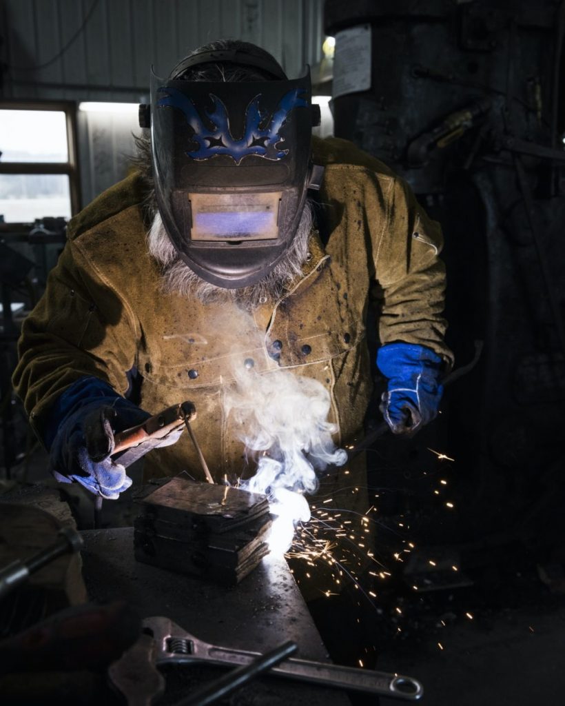 blacksmith-in-welding-mask-welding-metal-in-workshop-e1637761336407-pgjdjjfyvip4eazegdhddeal6g4vopbesvein9ljwg